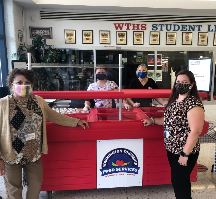 School lunch staff standing with kiosk cart